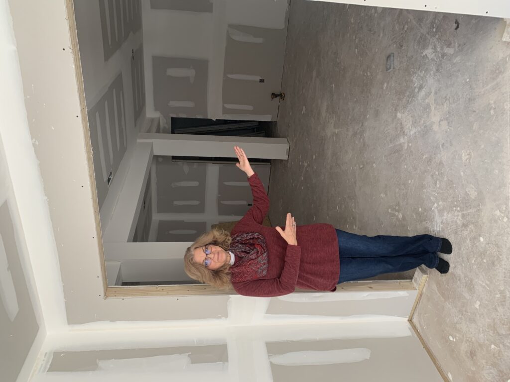Robyn standing in front of new studio space under construction.